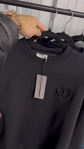 Black T-Shirt with brand logo on a hanger